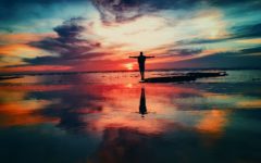 Silhouette Of Person Standing On Rock Surrounded By Body Of Water, from unsplash