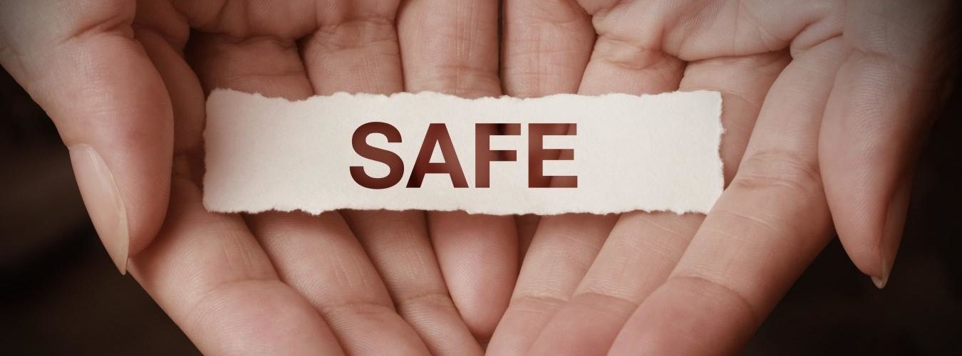 Two hands cradle the word 'safe'